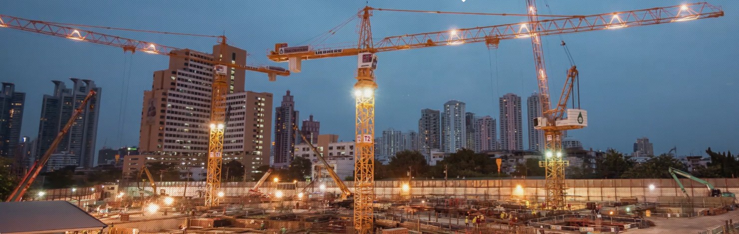 Construction site with tower cranes at dusk
